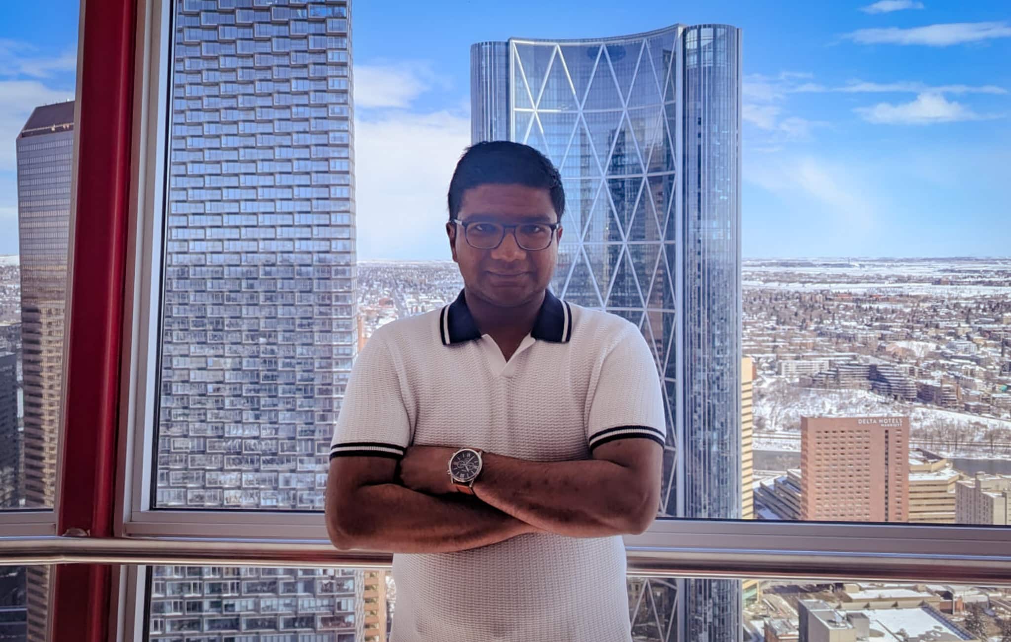 Picture showing Vishal standing in front of tall, pretty buildings of Calgary, Canada.
